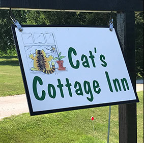 A sign for the cat 's cottage inn.